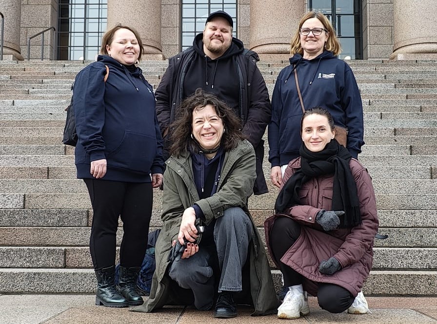 Työryhmän jäsenet Eduskuntatalon portailla.